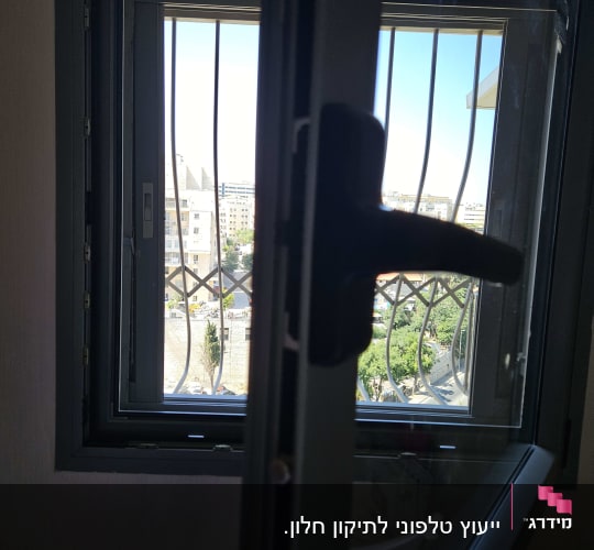 חלון פתוח עם תריסים וסורגים